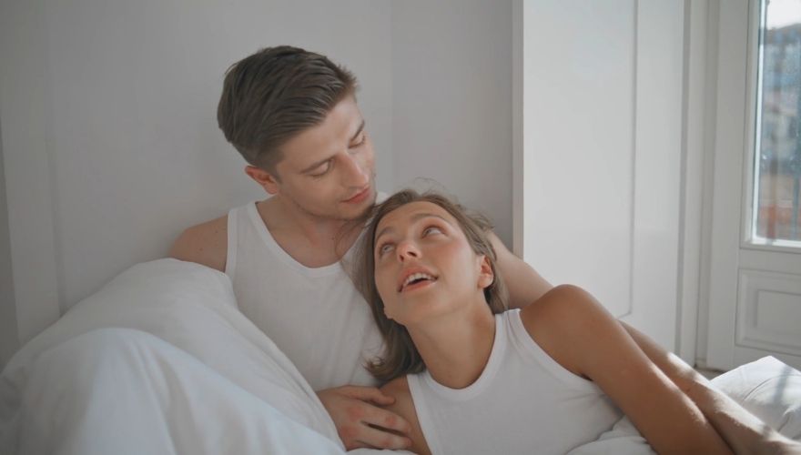 Couple relaxing together in bed and sharing a close, affectionate conversation.