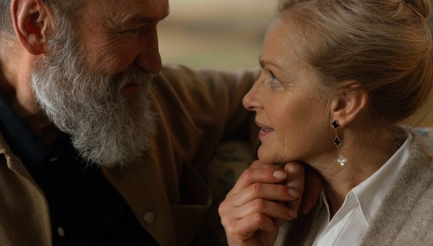 Older couple sharing a close, affectionate conversation while looking into each other’s eyes.