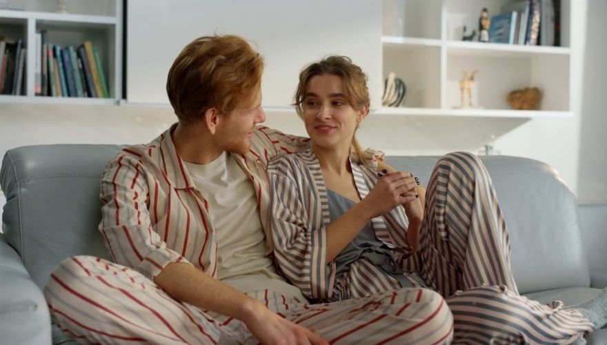 Couple sitting closely together on a couch and having a relaxed conversation at home.