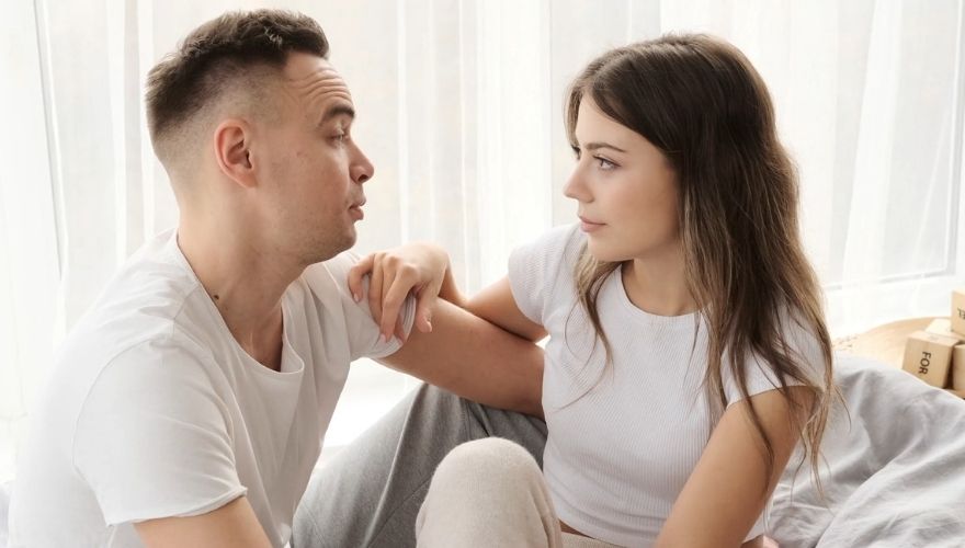 Couple having a serious face-to-face conversation while sitting together at home.